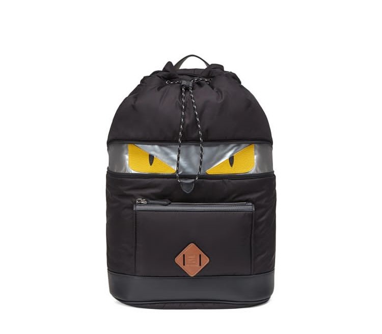 A black backpack with yellow eyes on it.