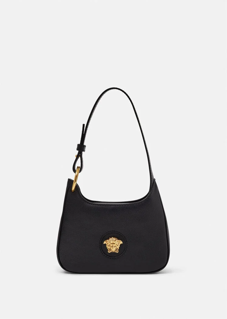 A black purse with a gold medusa head on the front.