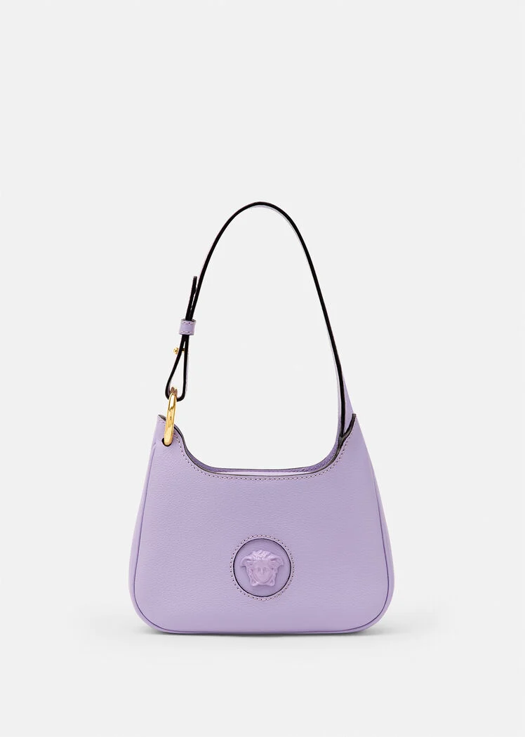 A purple purse with a black strap and a gold emblem.