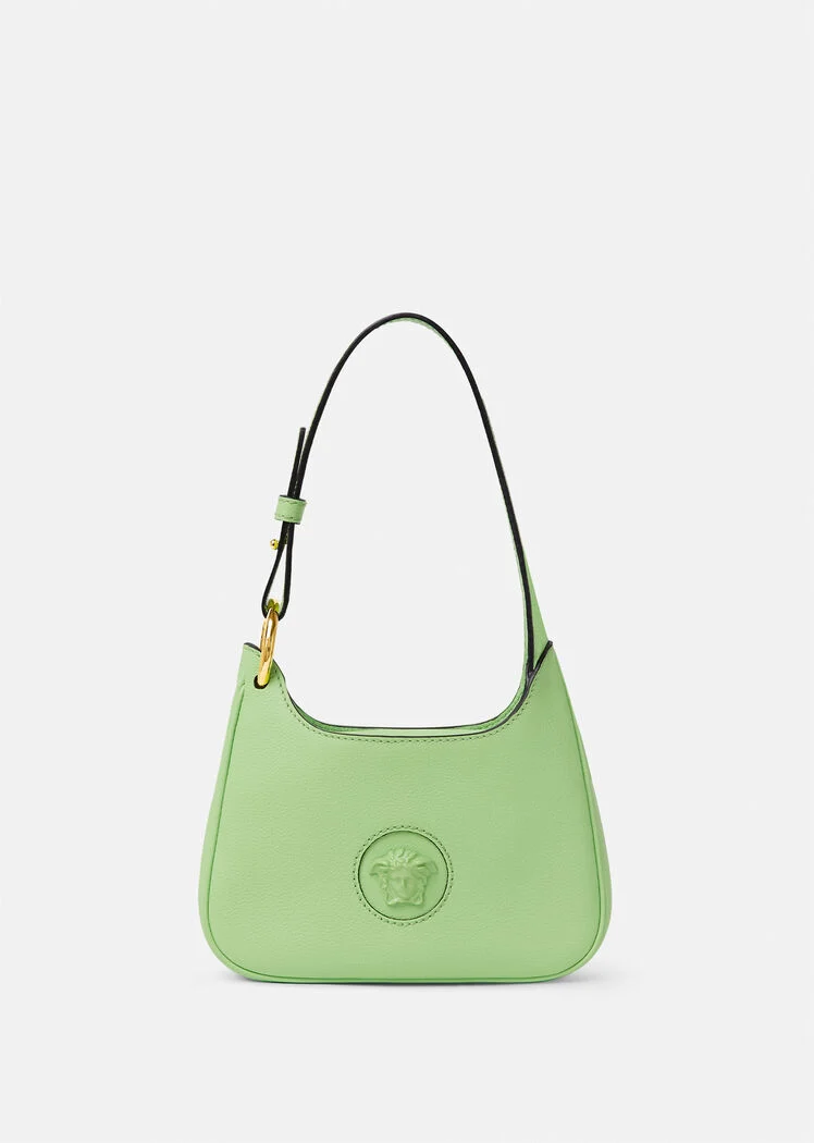 A green purse with a gold logo on it.