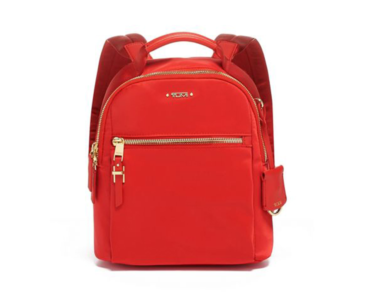 A red backpack with gold hardware and a small pocket.