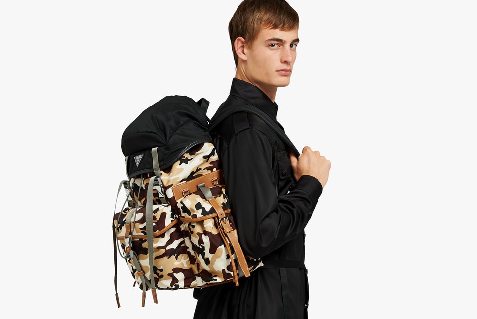 A man in black shirt and camouflage backpack.