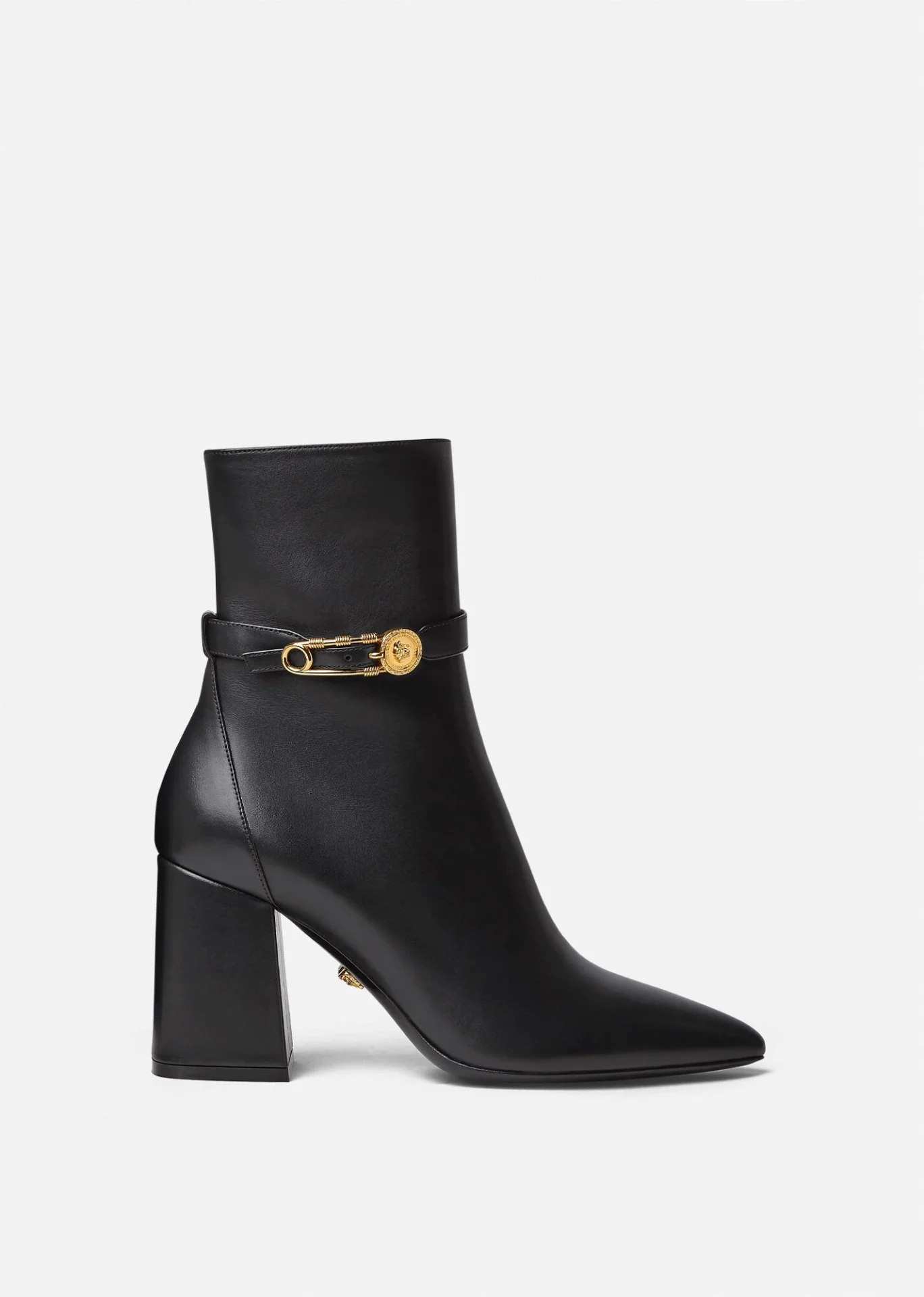 A black leather boot with gold hardware.