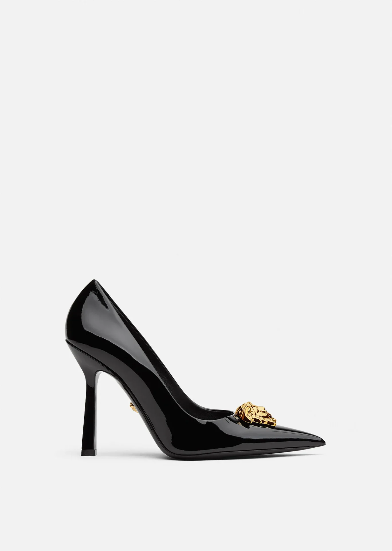 A black high heel shoe with gold detailing.