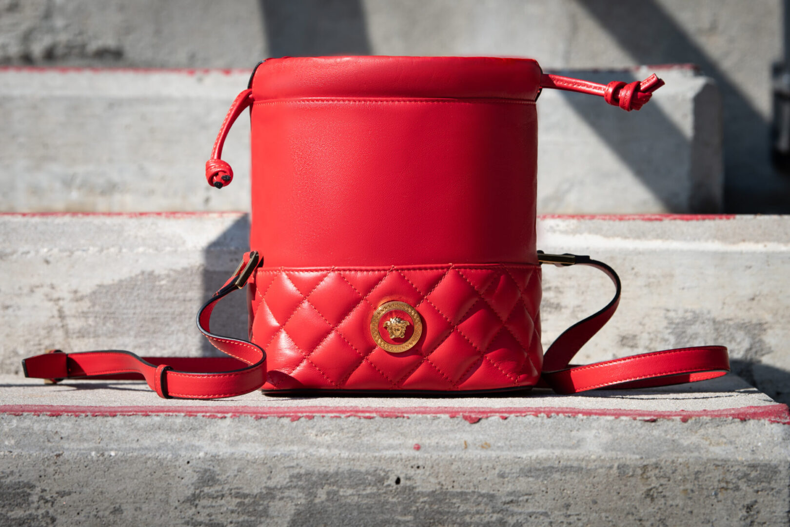 A red bag sitting on the ground outside.