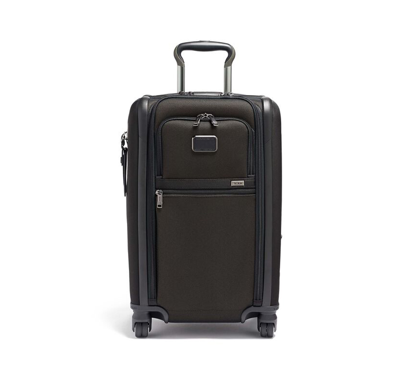 A black suitcase is sitting on the ground.