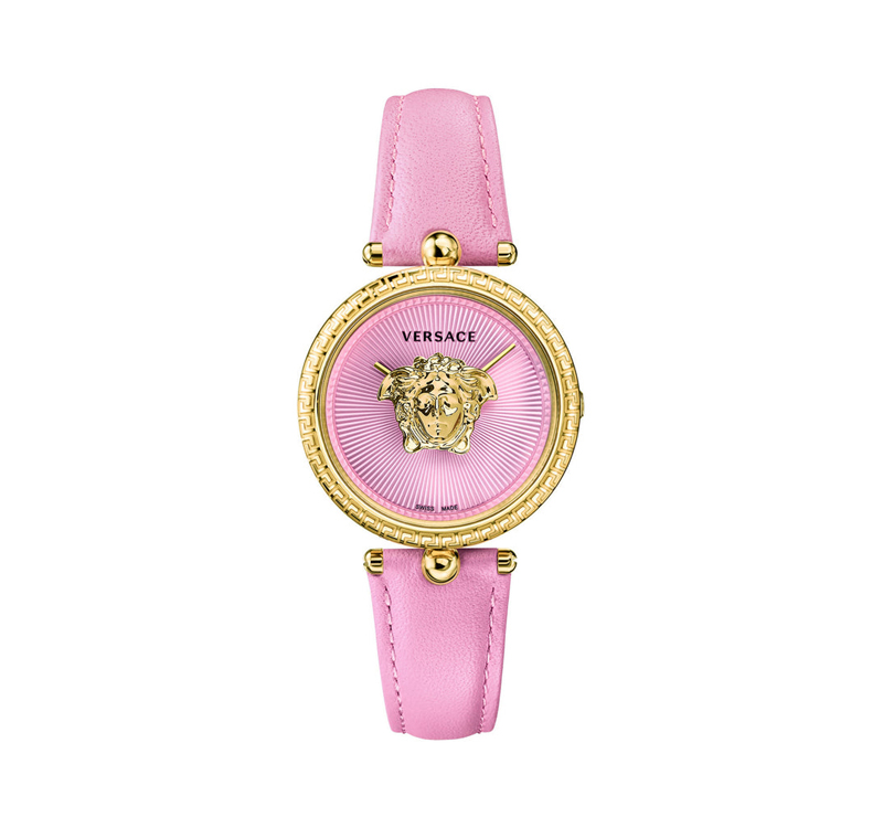 A pink watch with gold accents and a medusa face.