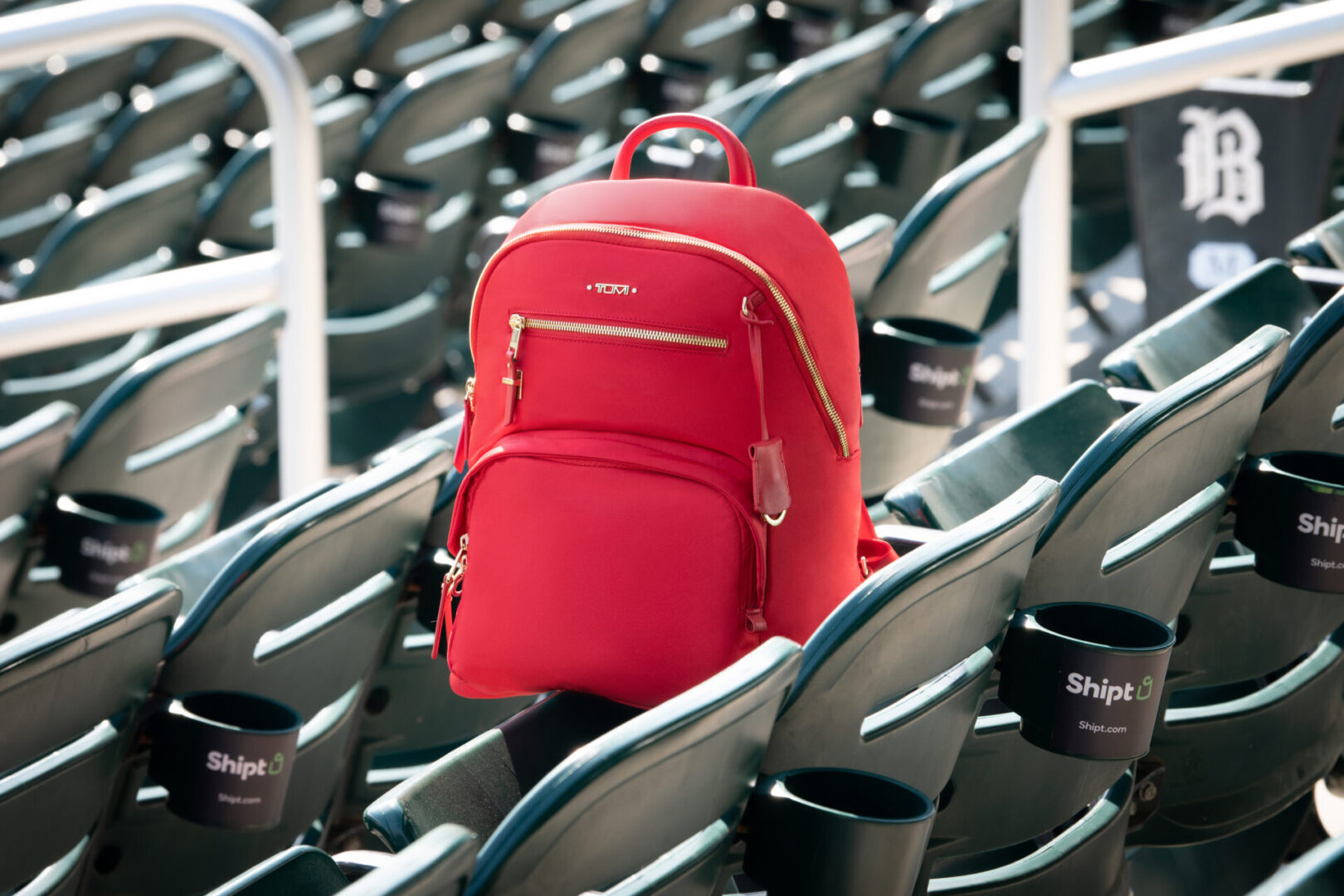 A red backpack sitting in front of some seats.